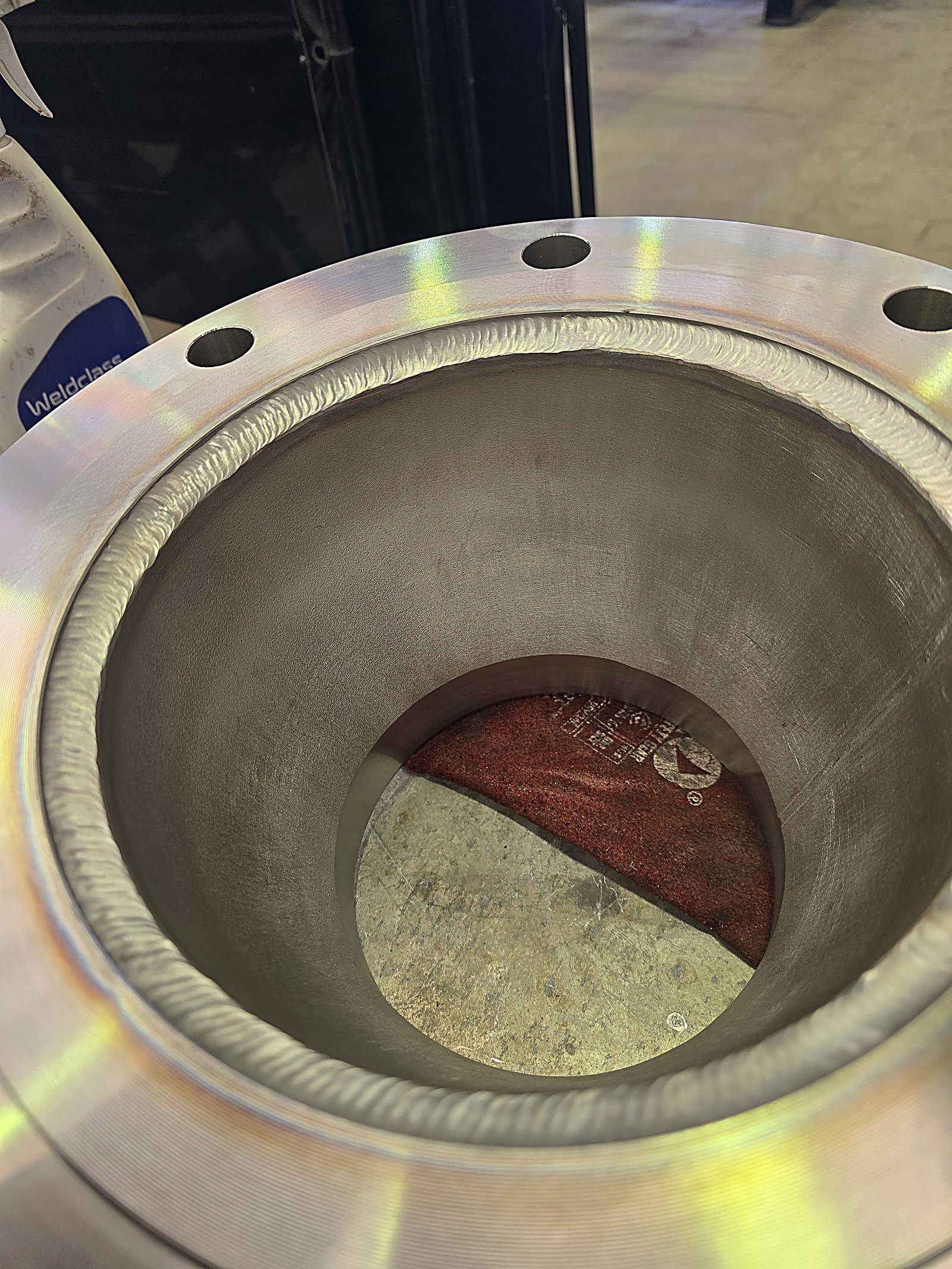 Close-up of a stainless TIG weld bead running around a flange joint